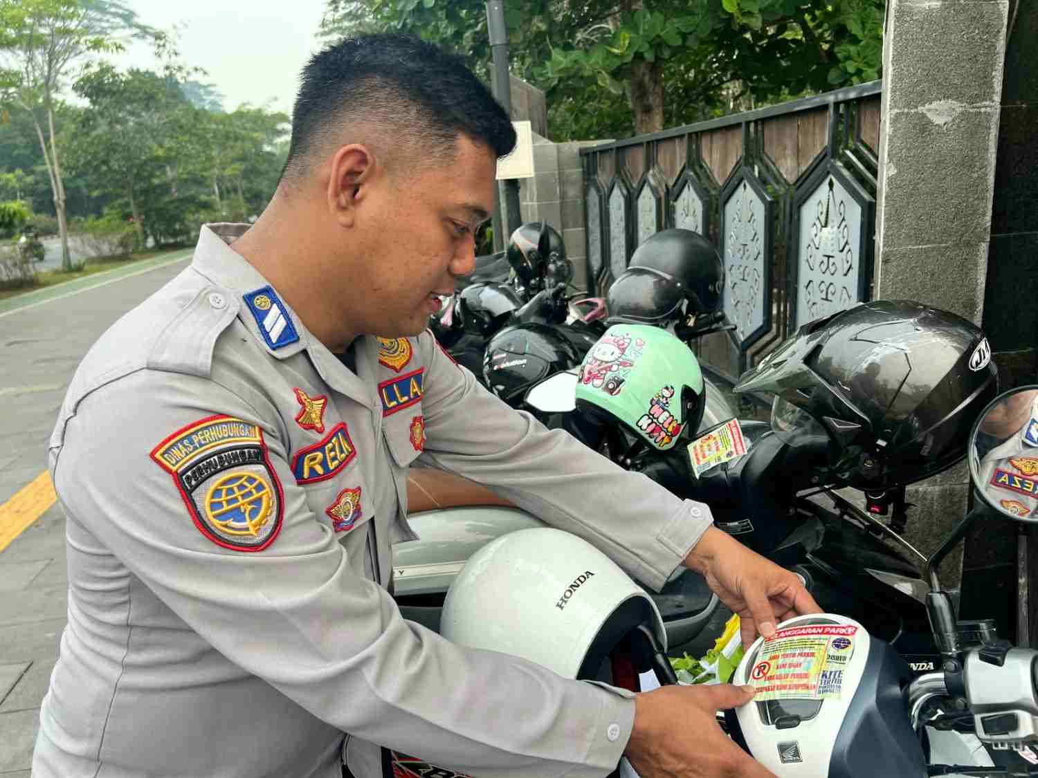 Petugas Dishub Kota Pontianak memasang stiker peringatan pada kendaraan yang parkir di atas trotoar saat pelaksanaan CFD, Minggu (4/10/2026).