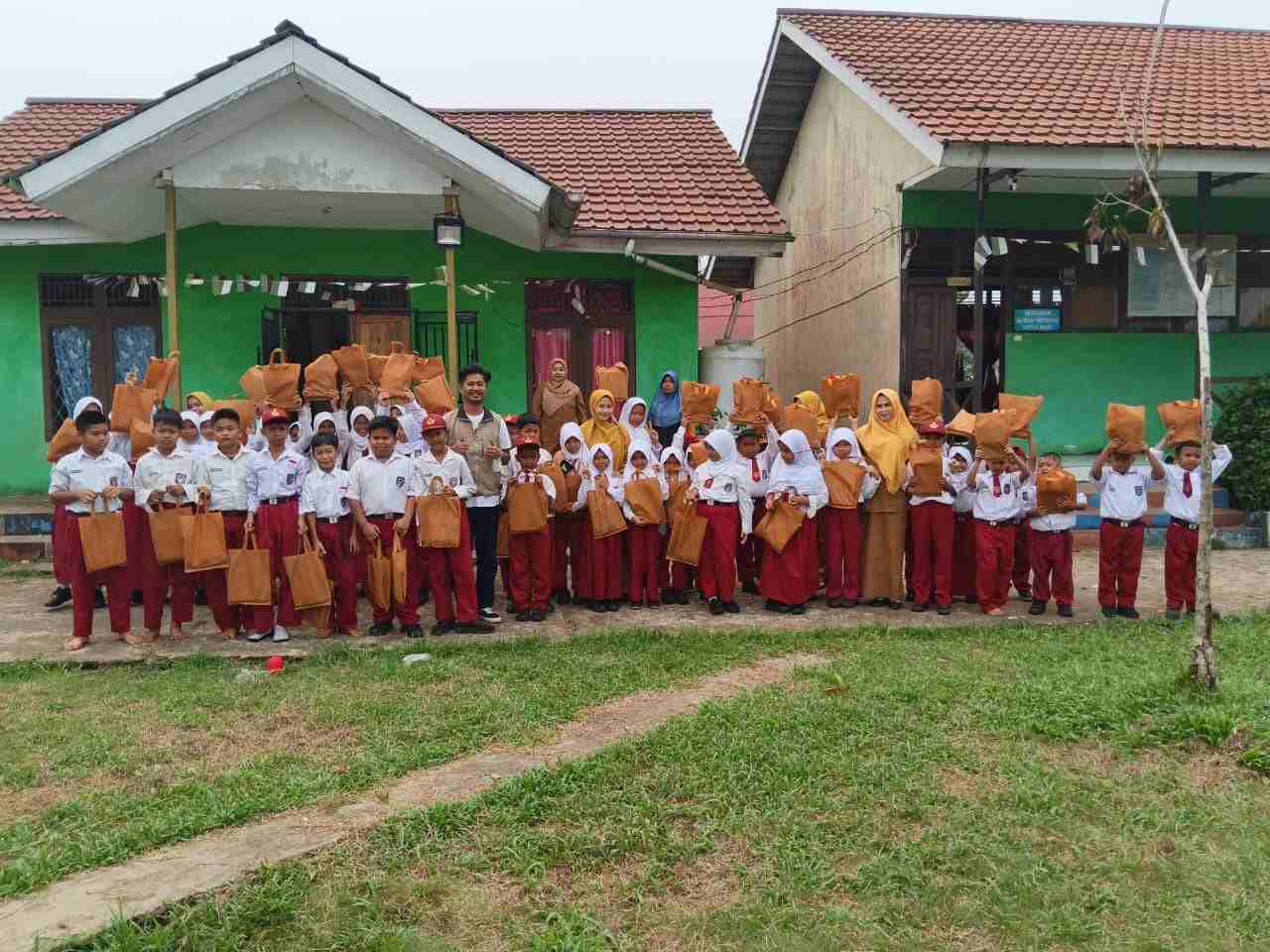Ketua Pemuda Muhammadiyah Kubu Raya, Unggul Ali Sadewo, bersama siswa-siswi SD Negeri 52 Sungai Raya saat kegiatan pembagian bantuan alat tulis dalam rangka Milad Muhammadiyah ke-114, di Kabupaten Kubu Raya, Senin (12/10/2026). Kegiatan ini merupakan bentuk kepedulian Muhammadiyah terhadap dunia pendidikan serta upaya mendukung semangat belajar dan meraih cita-cita bagi generasi muda.